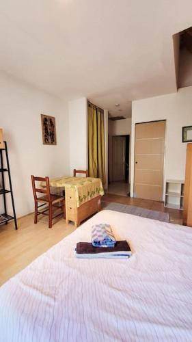une chambre avec un grand lit et une table dans l'établissement Apt avec extérieur, proche médiathèque, à Sète