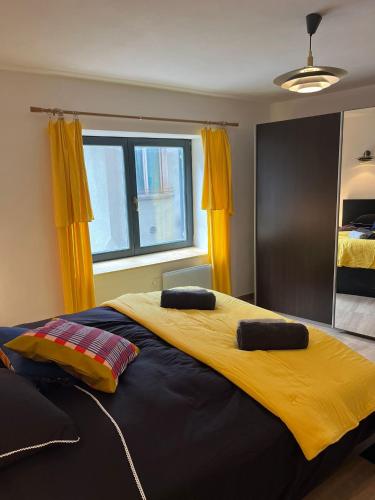 a large bed in a bedroom with yellow curtains at Hiša Blašč Wellness in Kobarid