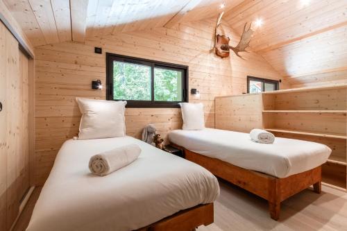 deux lits dans une chambre aux murs en bois dans l'établissement Chalet Soljanel, à Chamonix-Mont-Blanc