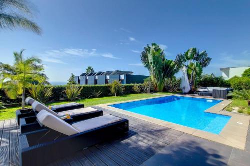 a swimming pool with two lounge chairs next to a swimming pool at Villa Ravenala - by LovelyStay in Funchal