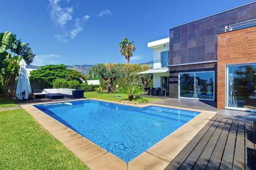 a swimming pool in front of a house at Villa Ravenala - by LovelyStay in Funchal