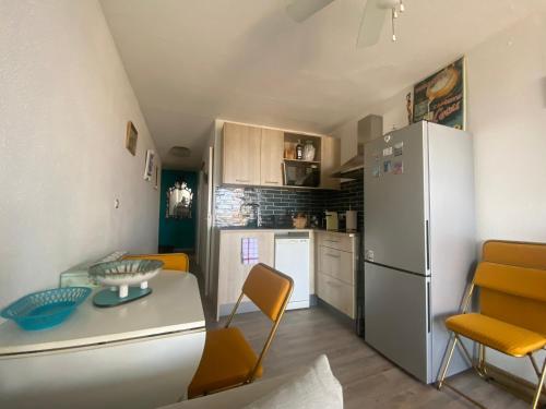 Il comprend une cuisine équipée d'un réfrigérateur, d'une table et de chaises. dans l'établissement Petit cocon vue sur la corniche de Sete, à Sète