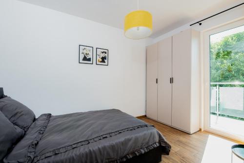 ein Schlafzimmer mit einem Bett und einem großen Fenster in der Unterkunft Apartament przy plaży in Gąski