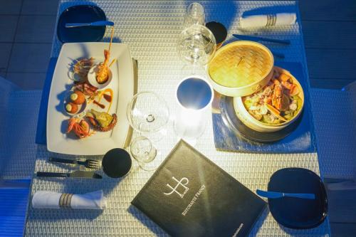 a table with a plate of food and a book at LHP Hotel Montecatini Palace & SPA in Montecatini Terme