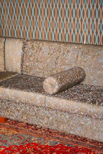 a brown couch with a pillow on it at Le Cedrus Hotel in Al Arz