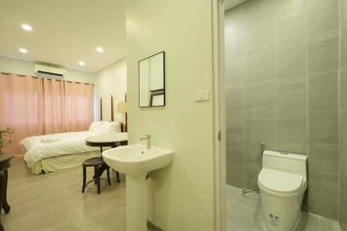 a bathroom with a toilet and a sink and a bed at XX Hidden Dragon Yaowarat Road ถนนเยาวราช in Samphanthawong