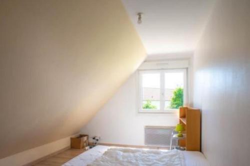 a white bedroom with a bed and a window at chez jules, l'entrée des caps in Bazinghen