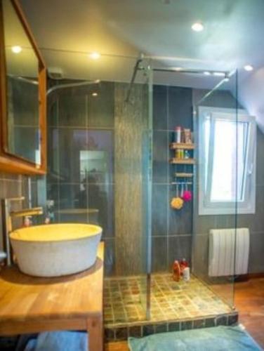 a bathroom with a tub and a glass shower at chez jules, l'entrée des caps in Bazinghen