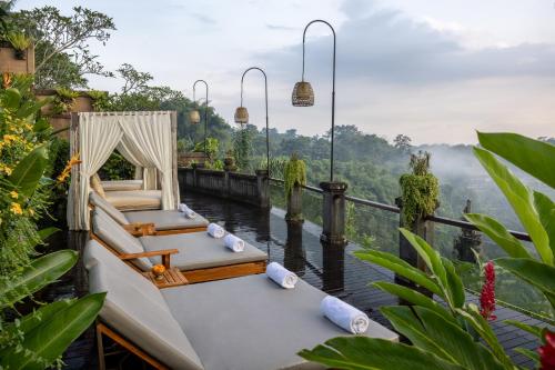 a room with two beds and a view of a river at Pramana Watu Kurung in Ubud