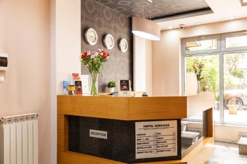 a room with a fireplace with clocks on the wall at Hotel Brod - Free Parking in Sofia