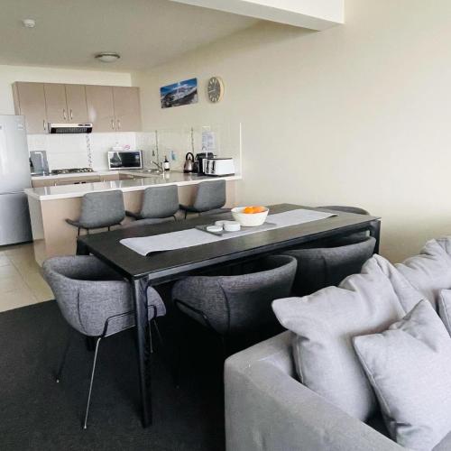 a living room with a table and chairs and a kitchen at Mountain View Chalet at Heidis in Smiggin Holes
