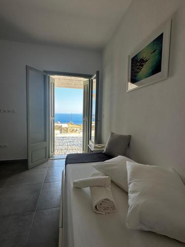 una camera da letto con un letto con vista sull'oceano di Psaraki House Serifos a Serifos Chora