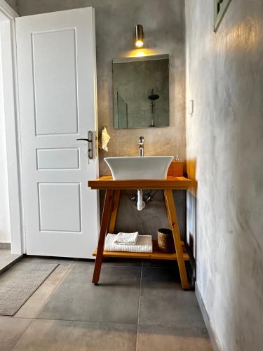 bagno con lavandino e porta bianca di Psaraki House Serifos a Serifos Chora