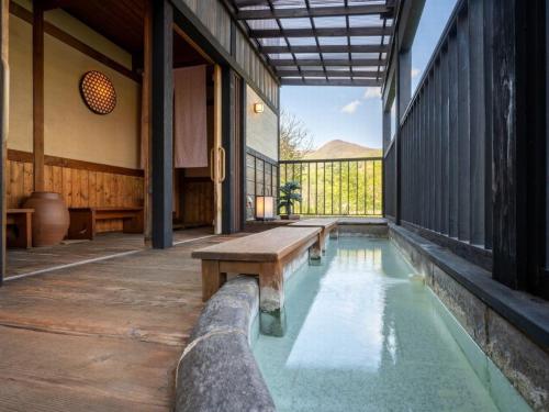 a pool with a bench in the middle of a house at 蔵王温泉 岩清水料理の宿 季の里 in Zao Onsen