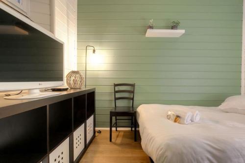 une chambre avec un lit et un bureau avec une télévision dans l'établissement Appartement bien équipé, Croix-Rousse, Lyon, à Lyon