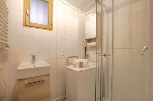 une salle de bain blanche avec un lavabo et une douche dans l'établissement Appartement bien équipé, Croix-Rousse, Lyon, à Lyon