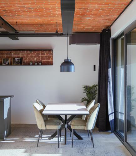 a dining room with a white table and chairs at Les Camuches de la fonderie in Tournai
