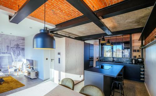 an open kitchen with a blue counter and chairs at Les Camuches de la fonderie in Tournai