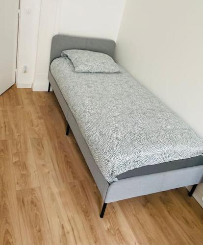 Ce lit se trouve dans un dortoir doté de parquet. dans l'établissement STADE DE FRANCE Superbe Appartement Proche Paris, à Saint-Denis