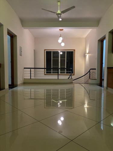 an empty room with a ceiling fan and a glass floor at Barefoot Homes, Varkala in Varkala