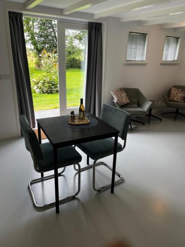 a living room with a black table and chairs at Meekhofsveen in Appelscha