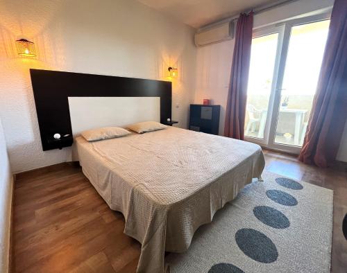 une chambre avec un grand lit et une grande fenêtre dans l'établissement SAINT-FLORENT Résidence piscine Studio 2 personnes FLO300-261, à Saint-Florent