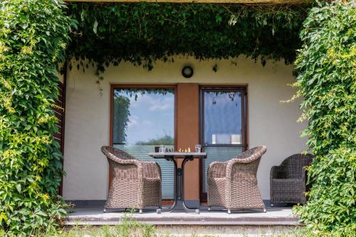 a table and chairs on a patio with a window at ATRIUM Apartamenty in Krynica Morska