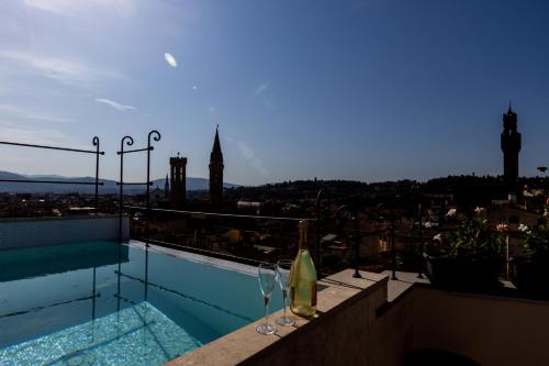 a pool with two wine glasses and a view of a city at Donati Luxury Tower Suites in Florence