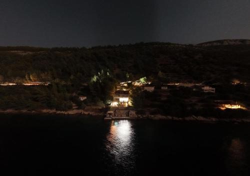 a night view of a house on the shore of a lake at Beach Villa Ratac in Slano