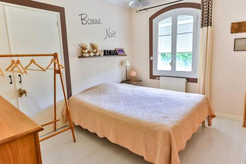 une chambre avec un lit et une fenêtre dans l'établissement Villa La Ponselière-Calme en campagne Provençale, à Graveson