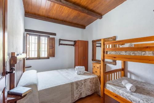 Un dormitorio con dos literas y una ventana. en Casa Rural El Ventorrillo, en Morón de la Frontera