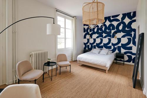 - une chambre avec un lit et un mur bleu et blanc dans l'établissement Maison Martouret - Colodge, à Andrézieux-Bouthéon