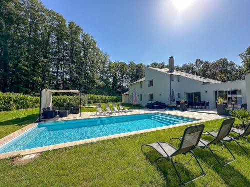 a swimming pool in the yard of a house at Villa avec piscine, Cinéma, terrain privé in Oisème