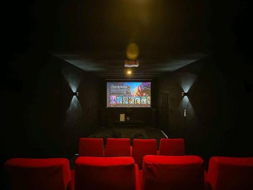 Cette chambre dispose de fauteuils rouges et d'une télévision à écran plat. dans l'établissement Villa avec piscine, Cinéma, terrain privé, à Nogent-le-Phaye