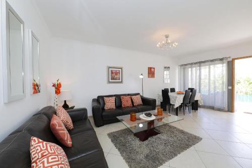 a living room with a couch and a table at Apt Mossbrae-tavira Centre, Terrasse Et Piscine in Tavira