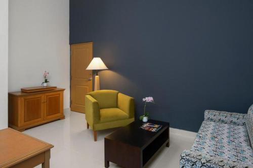 a living room with a yellow chair and a couch at Hodelpa Garden Suites - All Inclusive in Juan Dolio