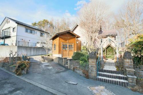 a house with a wooden door and a building at イングリッシュコテージ メイハウス in Oshino