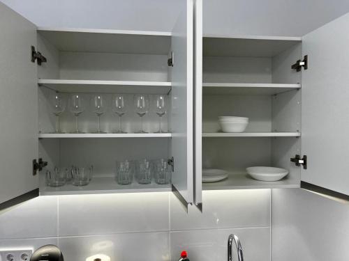 a kitchen with white cabinets with dishes and a sink at Rodrigues 15 in Valencia