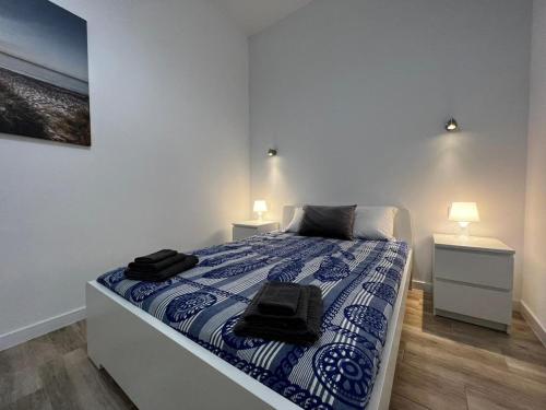 a bedroom with a bed with blue and white sheets at Rodrigues 15 in Valencia