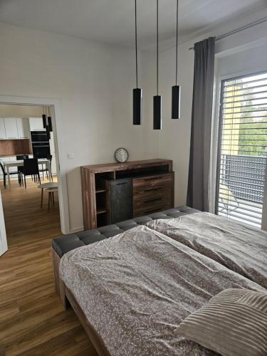 a bedroom with a bed and a dresser and a table at Euromiko apartment in Trenčín