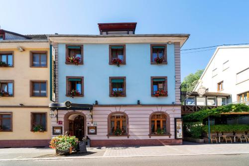 a white building with flowers in the windows at Hôtel du Parc, Restaurant, Spa & Wellness in Niederbronn-les-Bains