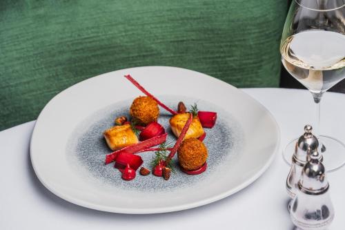 a plate of food on a table with a glass of wine at Borrowdale Gates Hotel in Keswick