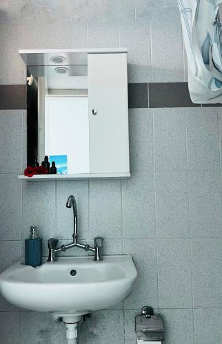 a bathroom sink with a mirror and a white cabinet at Anna Maria Rooms Santorini in Perissa