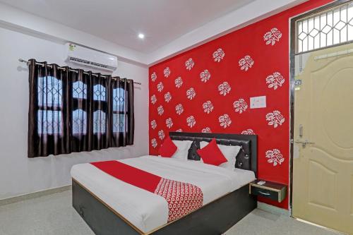 a bedroom with a bed with a red wall at Hotel O Sparrow Nest in Kakarmatha