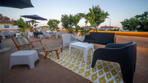 a patio with furniture and tables and chairs at Pato Rojo in Punta Umbría