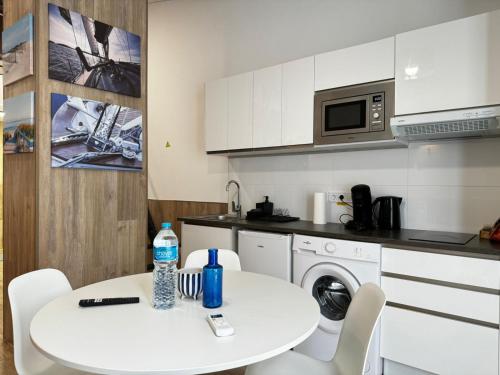 a small kitchen with a white table and a white sink at Rodrigues 15 in Valencia