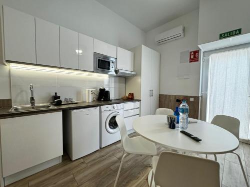 a kitchen with a white table and a table and chairs at Rodrigues 15 in Valencia