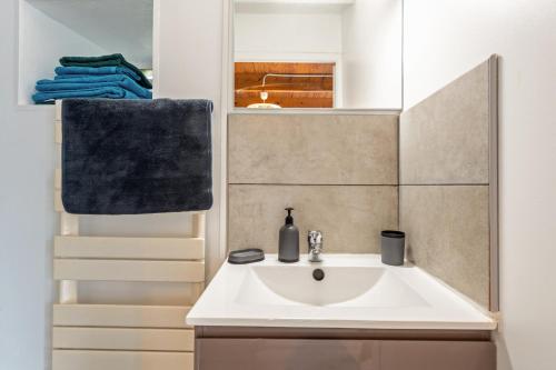 a bathroom with a white sink and a mirror at La Gitounette proche Monts d'arrée in Poullaouen