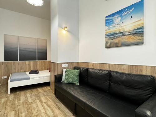 a living room with a black leather couch and a table at Rodrigues 15 in Valencia