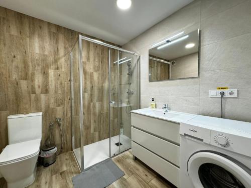 a bathroom with a shower toilet and a washing machine at Rodrigues 15 in Valencia